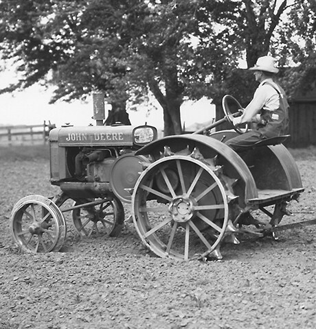 Tarlada 7 Numaralı John Deere Döner Çapayı çeken tarihi John Deere "GP" Genel Amaçlı Traktör