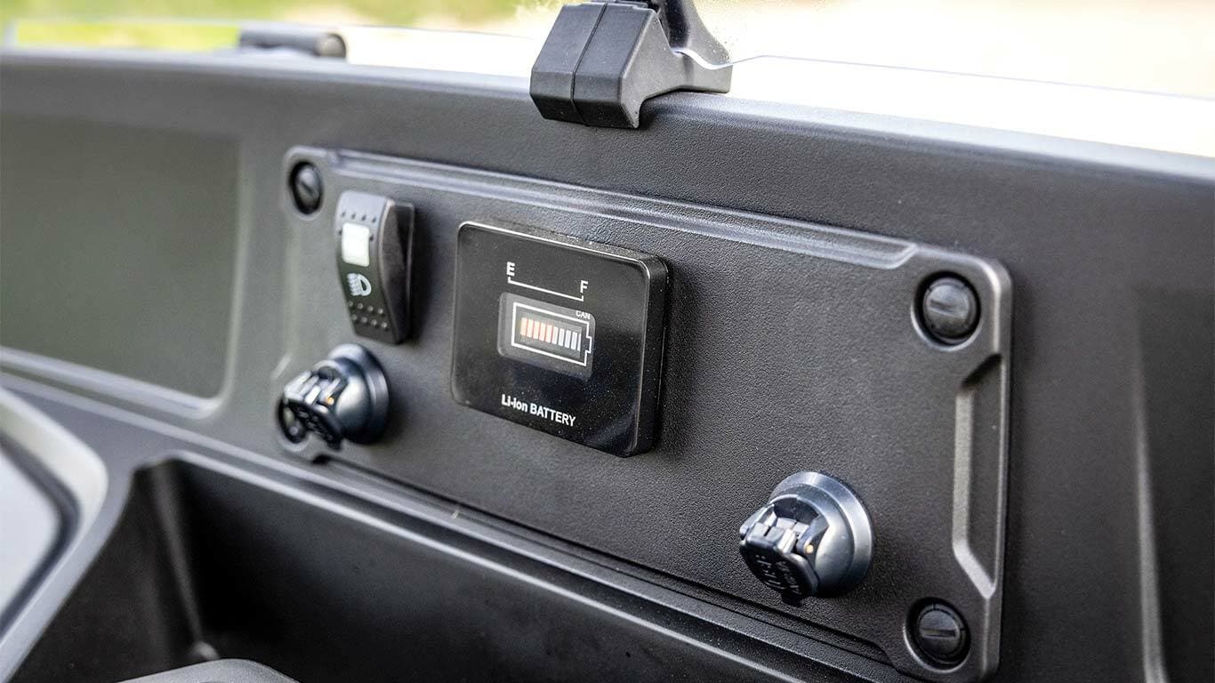 Akü seviyesi göstergesini ve güç bağlantı noktalarını gösteren John Deere Gator GS elektrikli modelinin gösterge paneli.