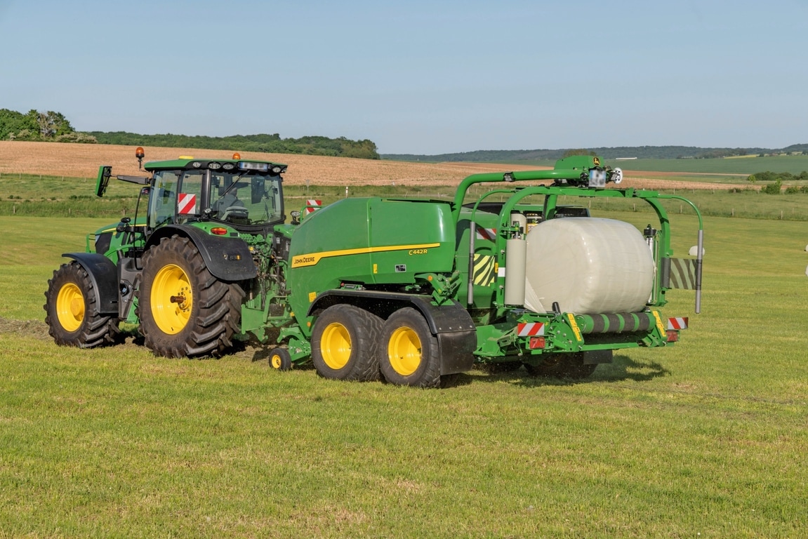 Bir John Deere 6R 185 tarafından çekilen John Deere C442R sarıcı balya makinesi yüksek yoğunluklu silaj balyalama yapıyor